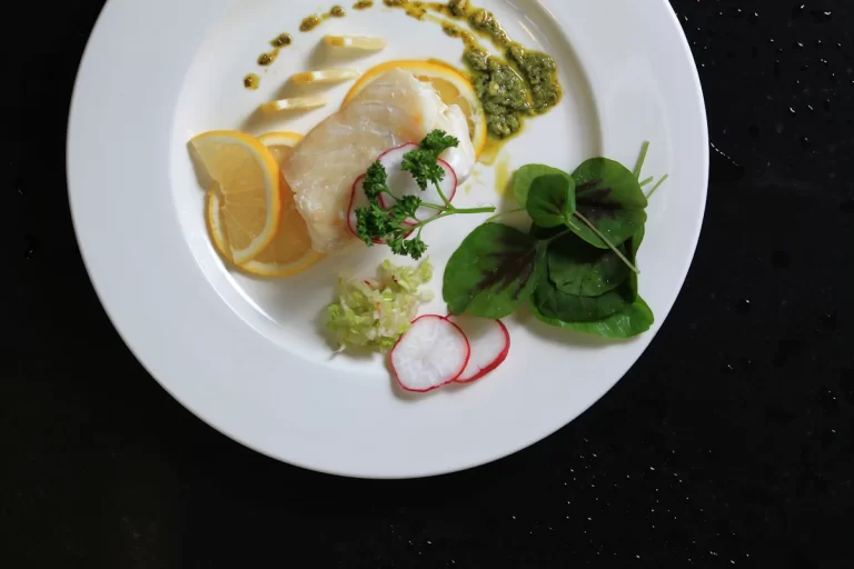 Une assiette de filet de limande avec quelques herbes fraîches et du citron