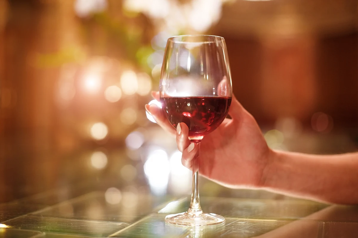 Une personne qui tient un verre de vin