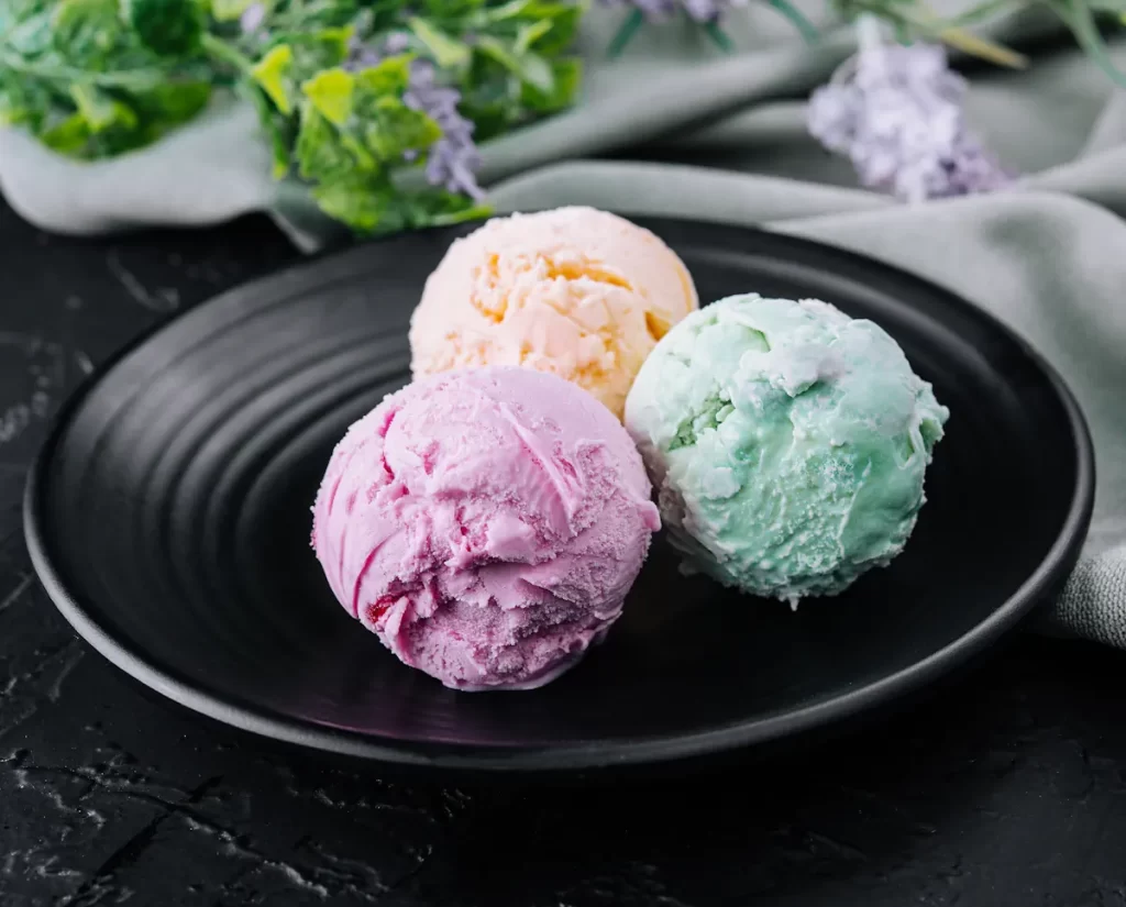 Une assiette avec 3 boules de glace de différentes couleurs