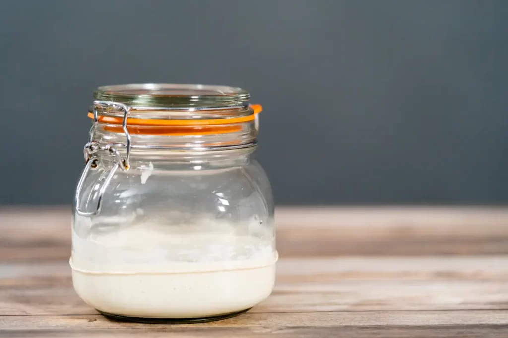 Un pot de mayonnaise en verre fermé posé sur une table en bois