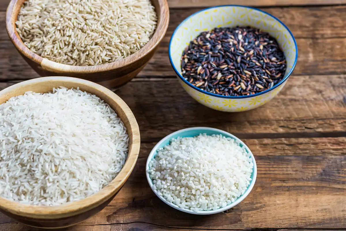 Différentes variétés de riz dans des bols posés sur une surface en bois