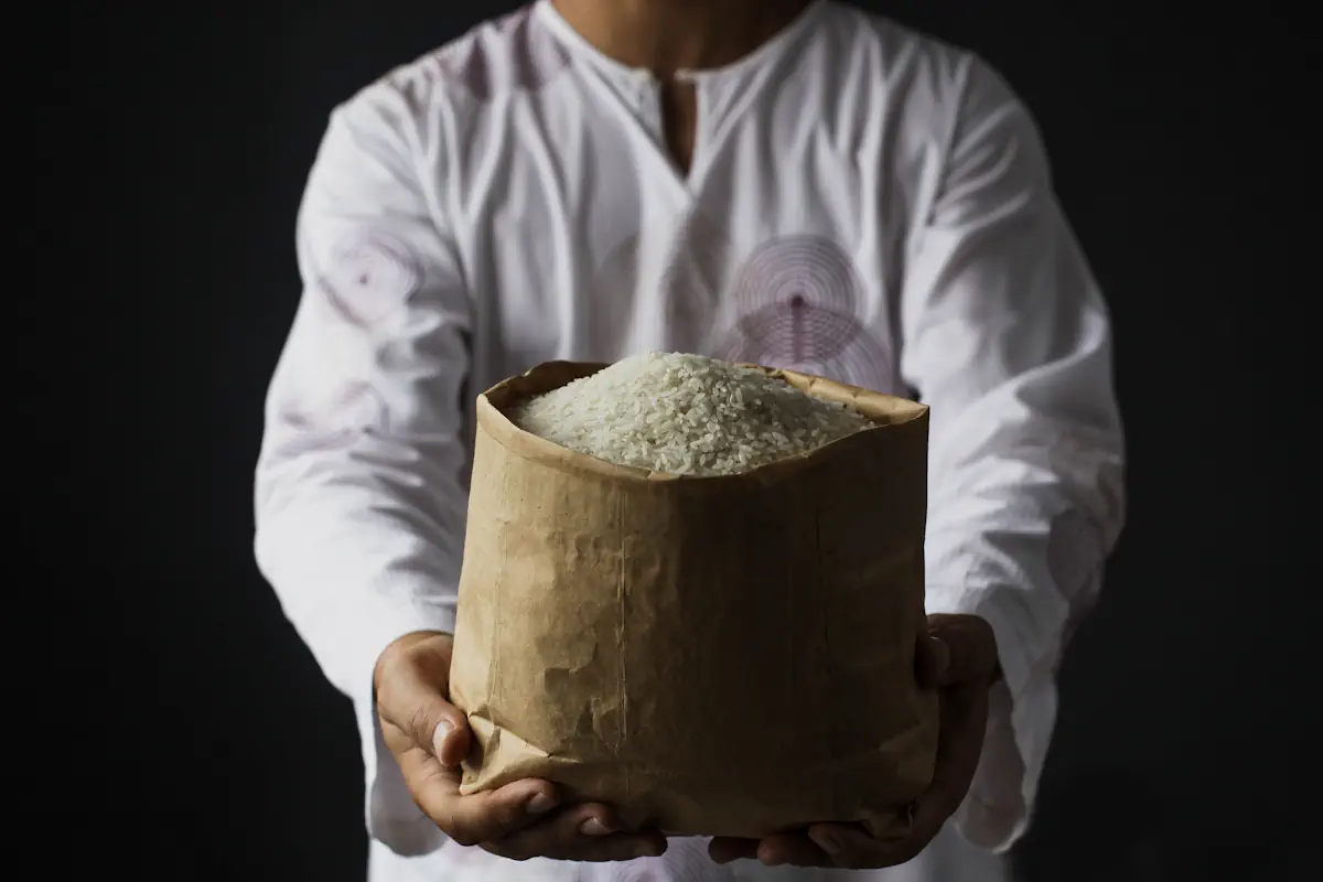 Une personne qui tend un sac de riz